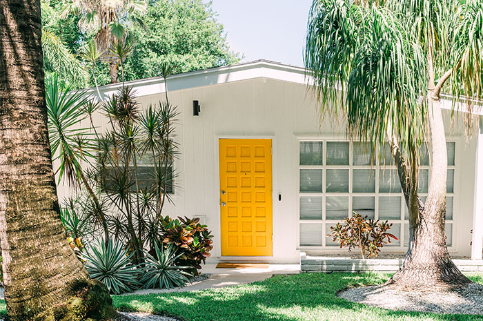 Contemporary white home with geometric yellow front door.