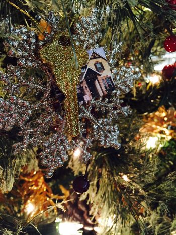 DIY glitter house key ornament hanging on tree.