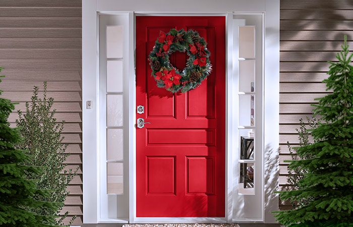 Red front door with Christmas wreath and Schlage bright chrome door locks.