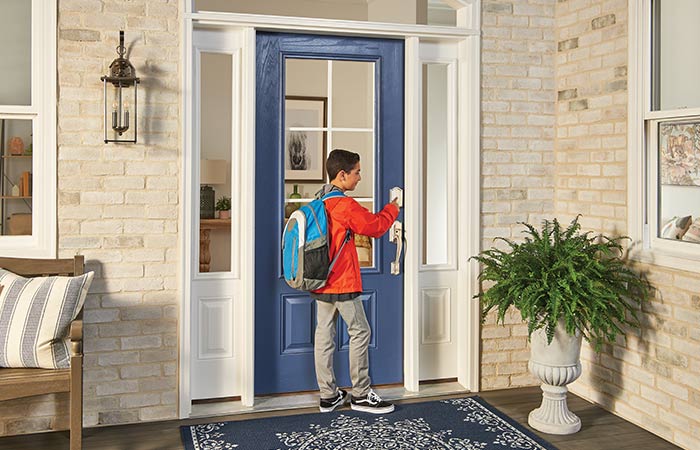 Child with backpack unlocking front door smart lock