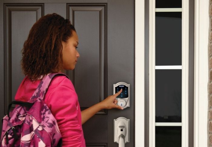 Girl with backpack unlocking Schlage Connect Smart Deadbolt.