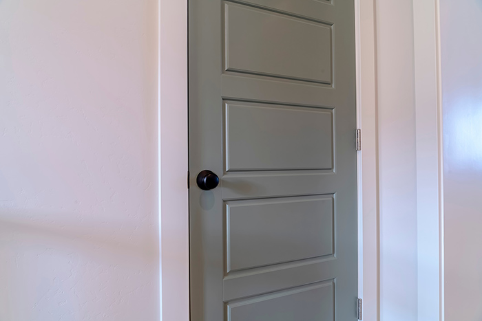 Sage bedroom door with black door knob.