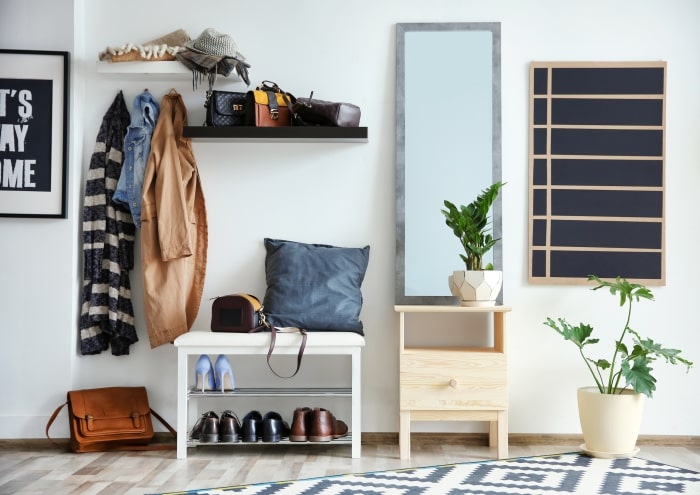 Clean entryway with coat rack and shoe storage.