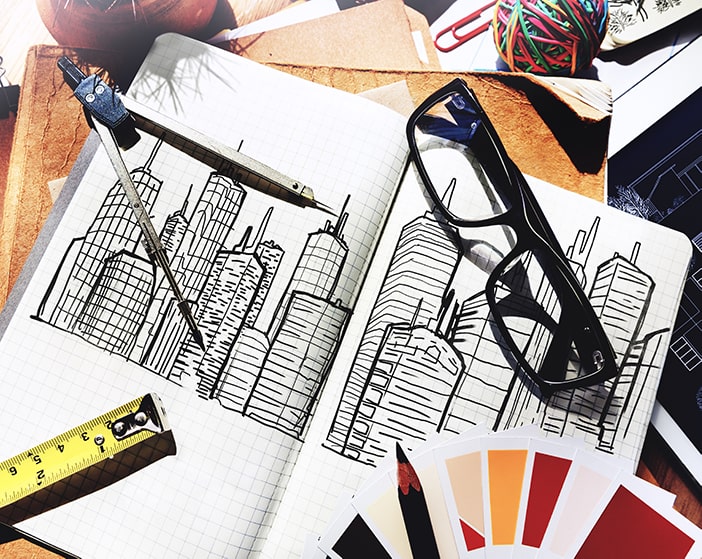 Architect's desk with sketches, glasses and swatches.