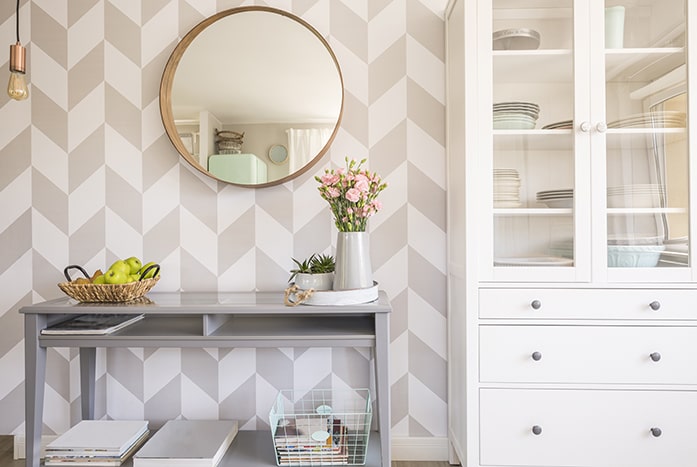 Bright dining room console with geometric wallpaper.