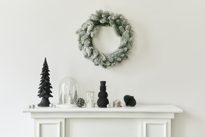 Black and white holiday mantel with black snowman decor.