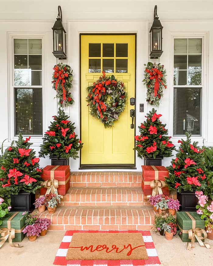 Simply Southern Cottage yellow front door with red Christmas decor.