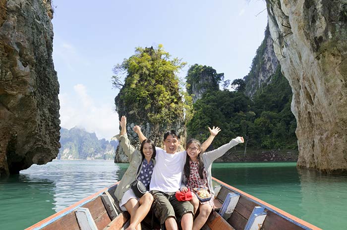 Happy family on vacation in boat on lake.