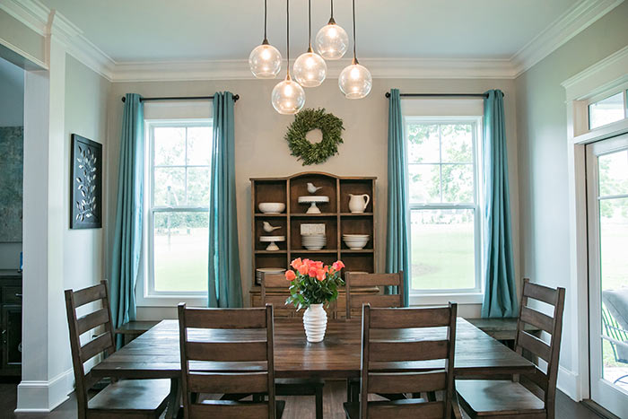 Farmhouse dining room with vase of tulips on table.