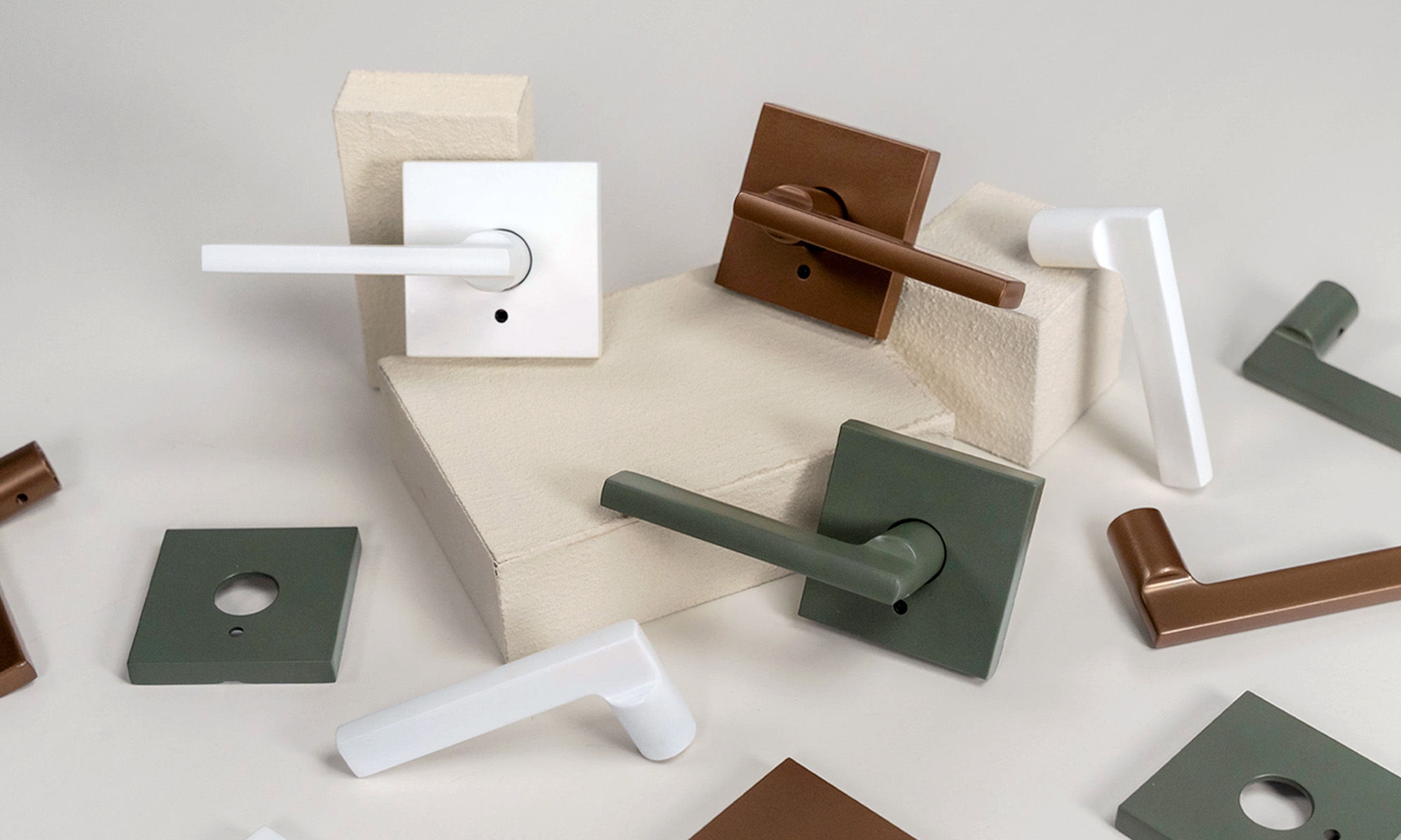 Artistic arrangement of Schlage's premium copper, white, and green door levers.