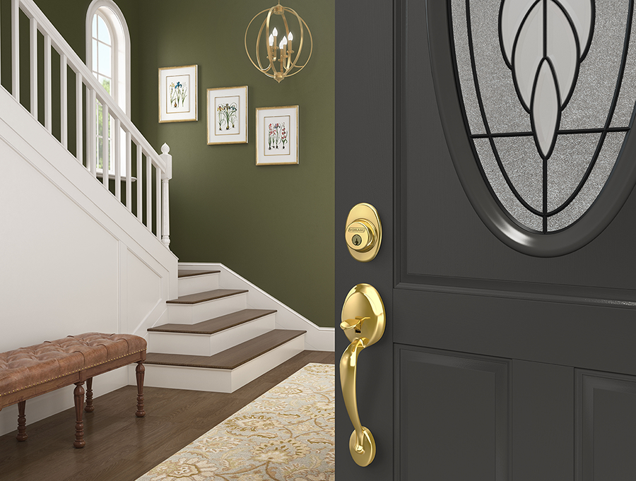 Dark forest green front door with bright brass deadbolt and door handle.