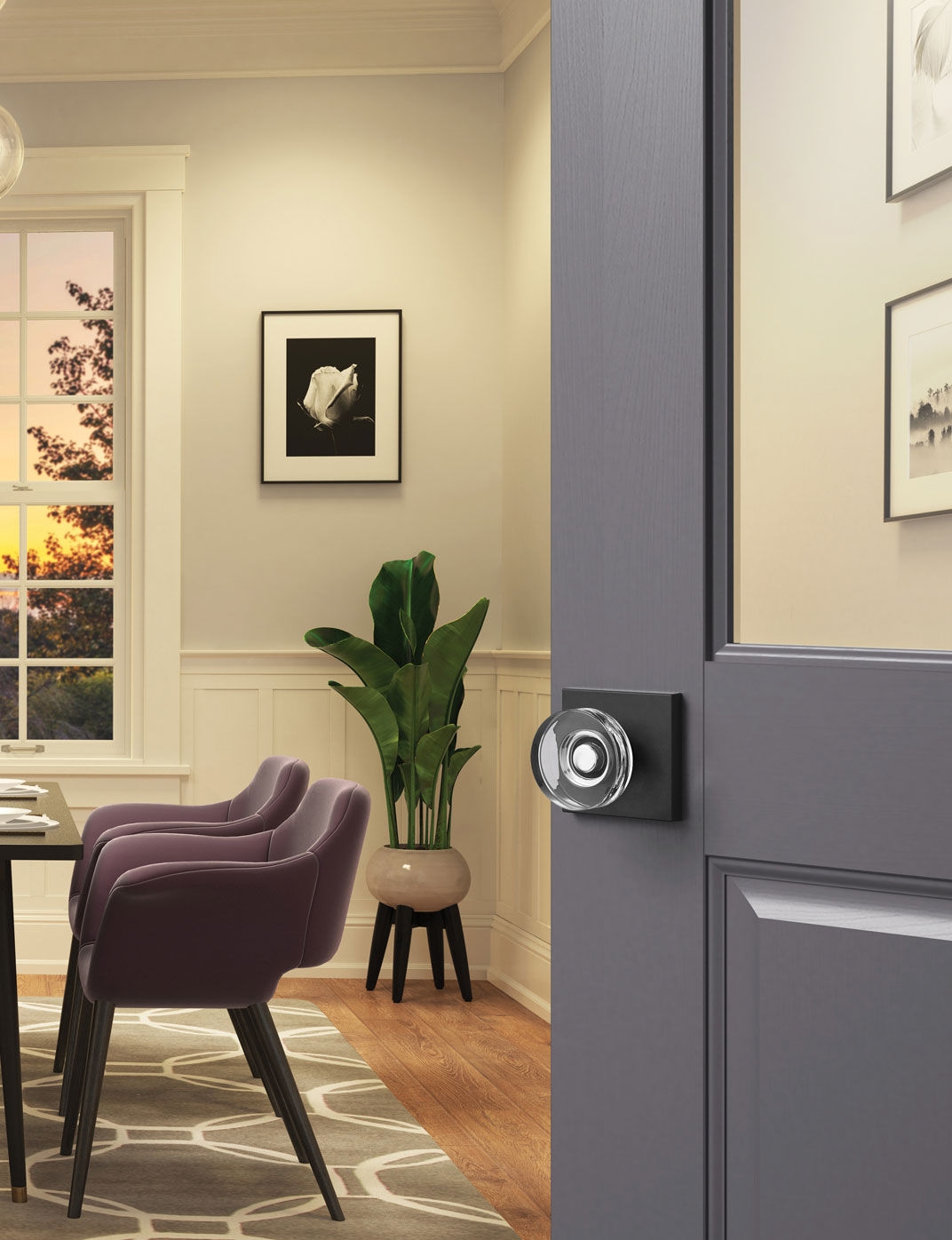 Glass door knob with matte black rosette on a dining room door.