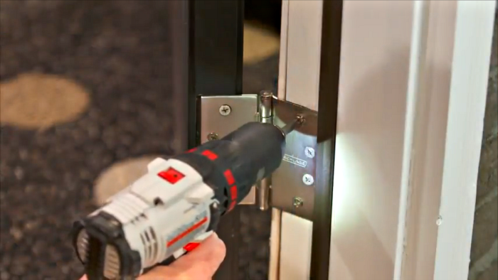 Installing door hinges with drill.