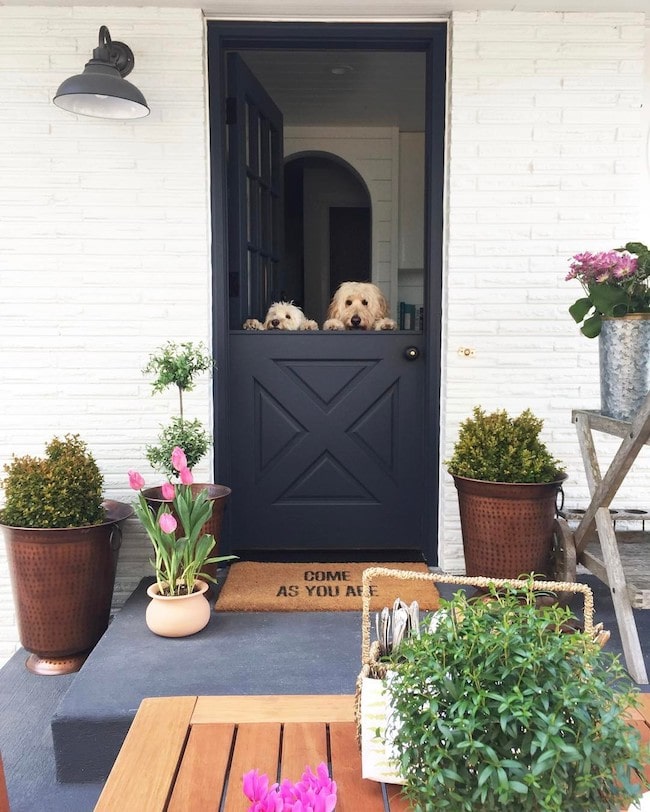 Colorful front porch planters in bright blue pots.