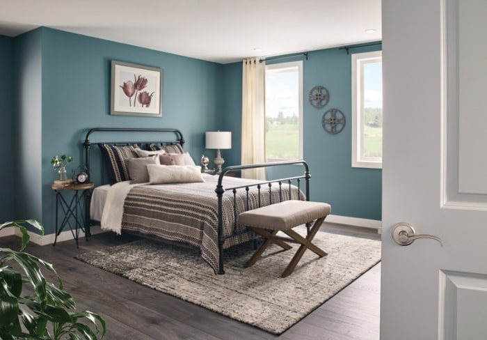 Master bedroom with teal walls, black iron frame bed and satin nickel Schlage Custom door hardware.