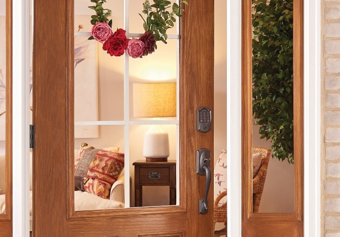 Pink floral minimal wreath on front door with Schlage smart lock.