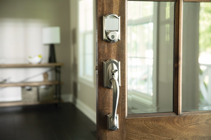 Schlage Sense Smart Deadbolt with Satin Nickel grip on glass front door.