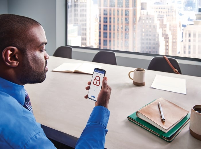 Man viewing the Schlage Home app on his iPhone at the office.