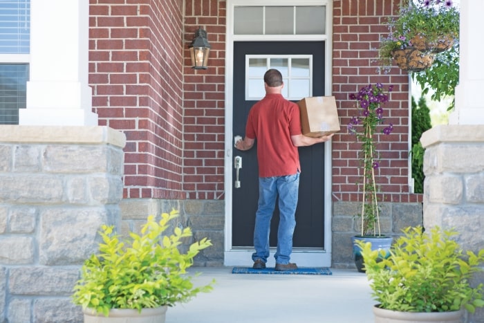 Man at front door with smart lock.