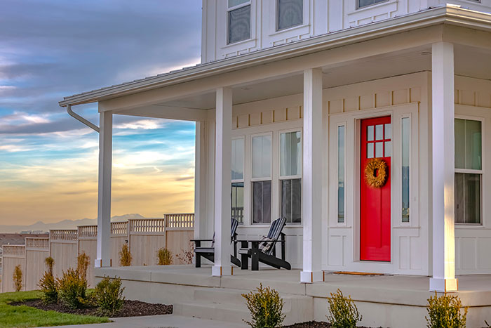 White vacation home with bright red front door.