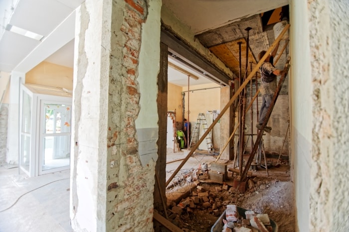 Man on ladder remodeling home.