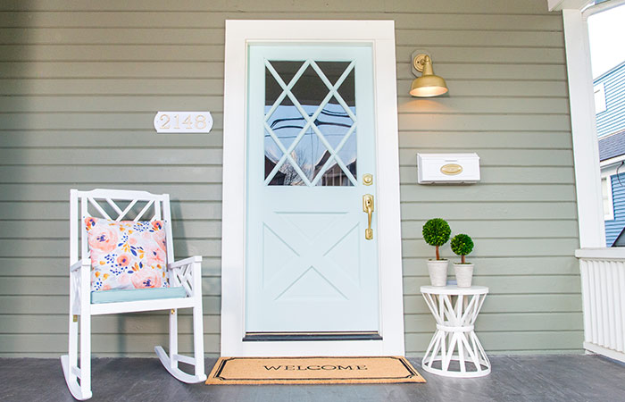 Light blue front door with satin brass Schlage Custom door hardware.