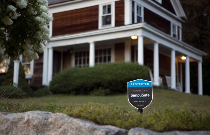 SimpliSafe security sign in front of home.