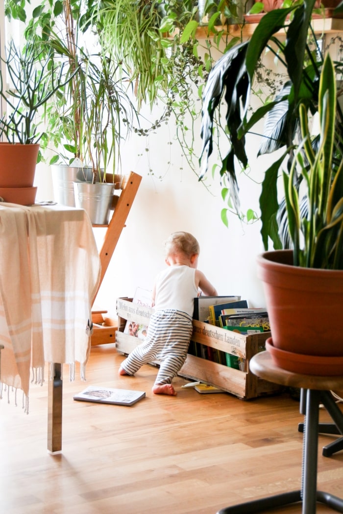 Baby digging through crate of books