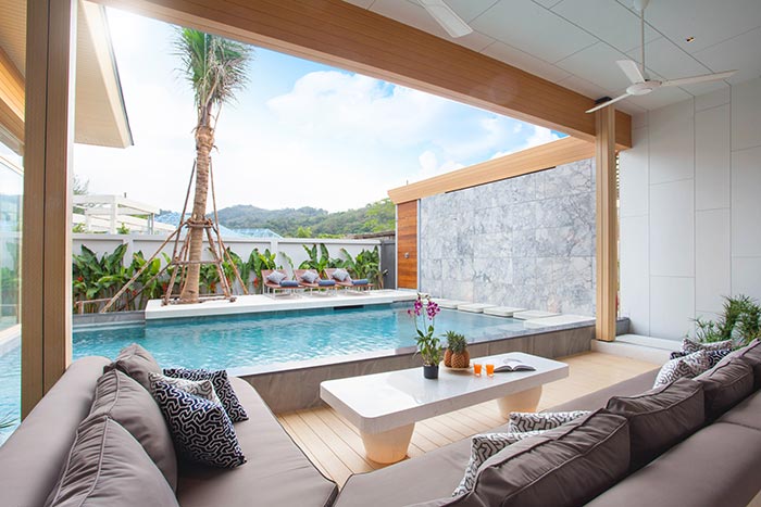 Tropical vacation home living room open to outdoor pool.