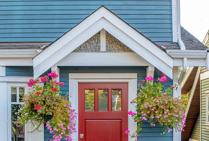 Small front porch with hanging summer flowers.