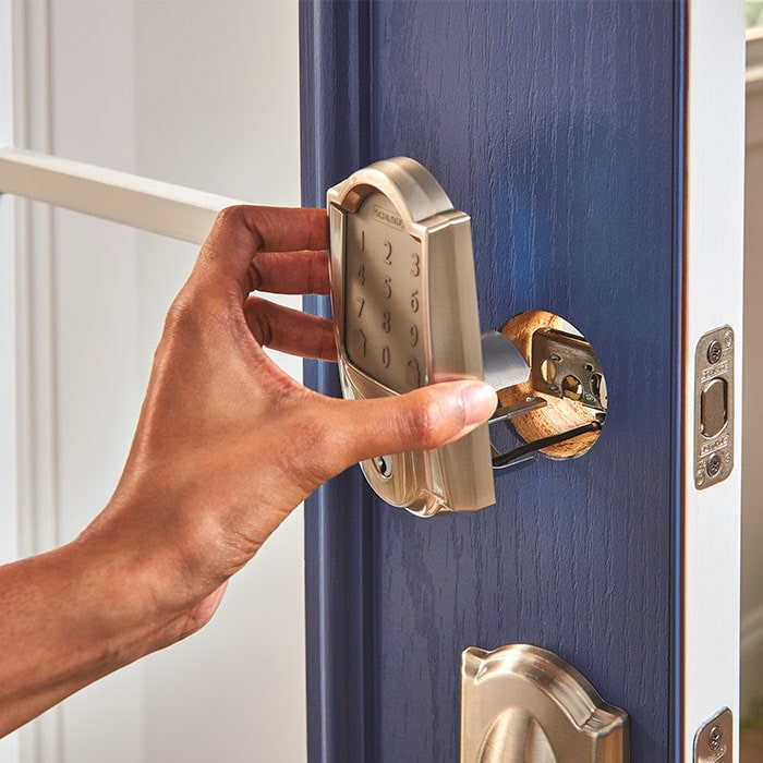 Hand installing Schlage Encode smart lock.