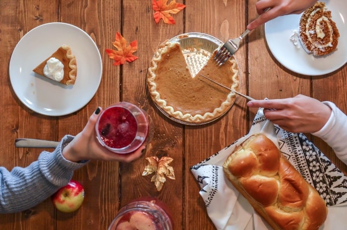 Thanksgiving table with pumpkin pie and drinks.