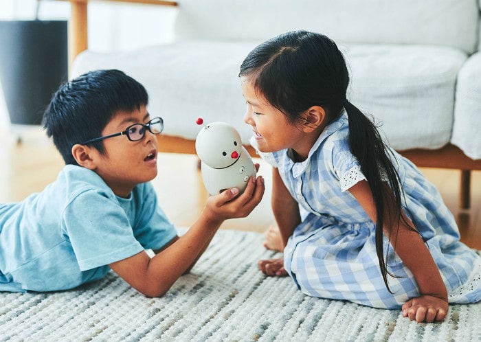 Kids holding BOCCO emo communications robot