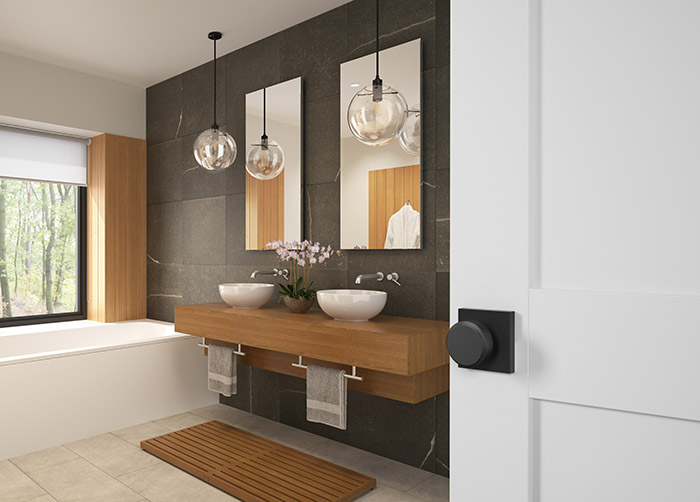 Modern bathroom with stone tile and Schlage black door knob.