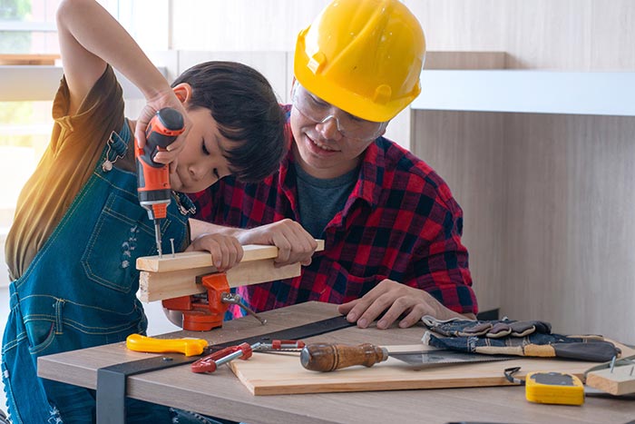 Father teaching son how to use tools.