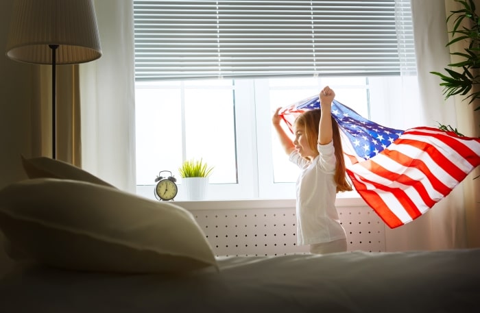 Little girl running with American flag.