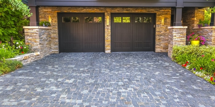 Stone home with dark garage doors.