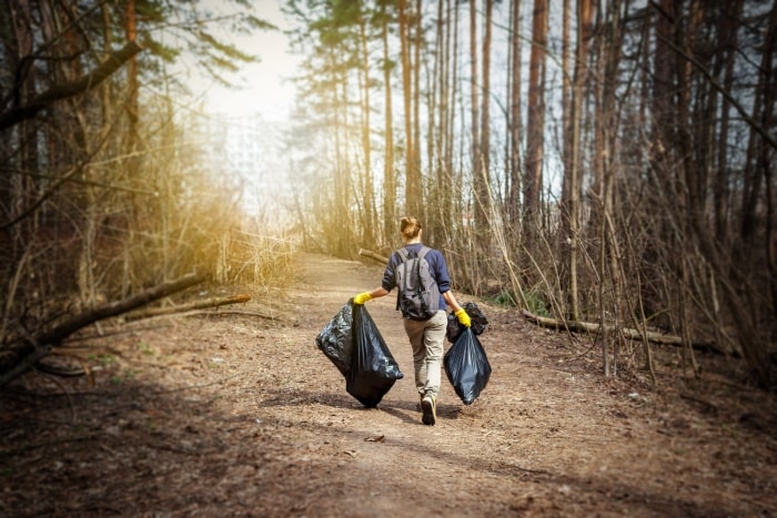 Volunteer picking up trash along walking trail.