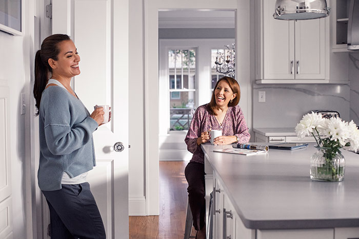 Women talking in kitchen with Schlage glass door knob.