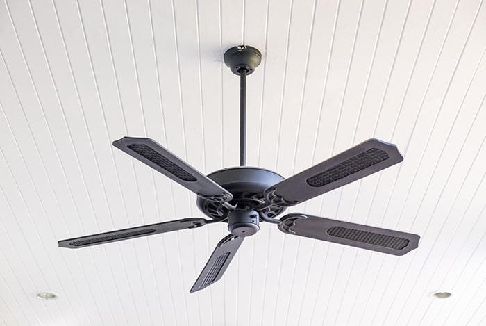 Black ceiling fan on beadboard ceiling.