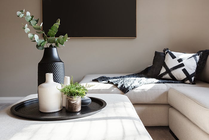 Living room with vase decor on ottoman.