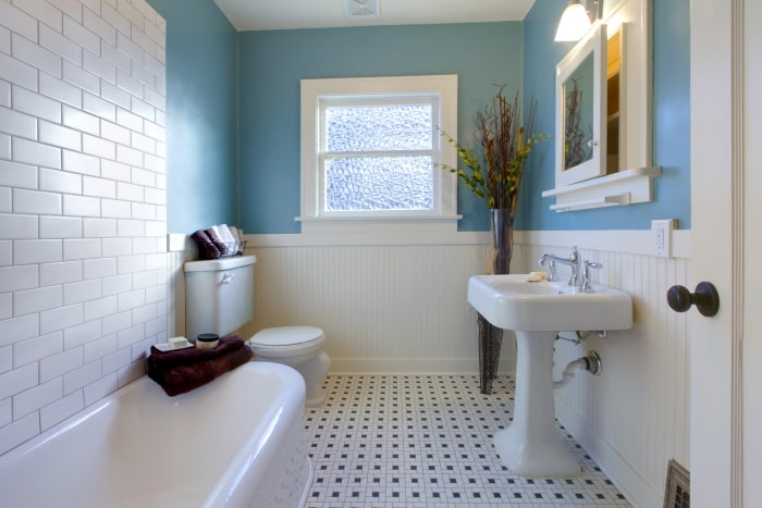 Bathroom with black and white tile and blue walls.