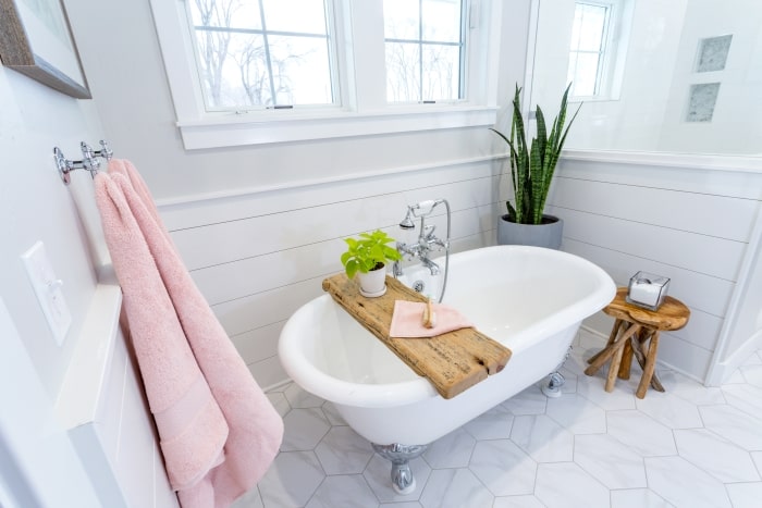 Farmhouse bathroom with marble tile clawfoot tub.