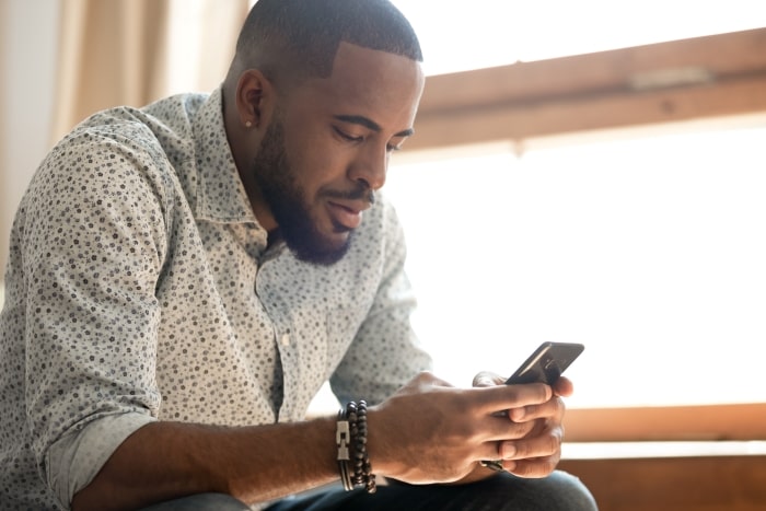 Man at home looking at smartphone.