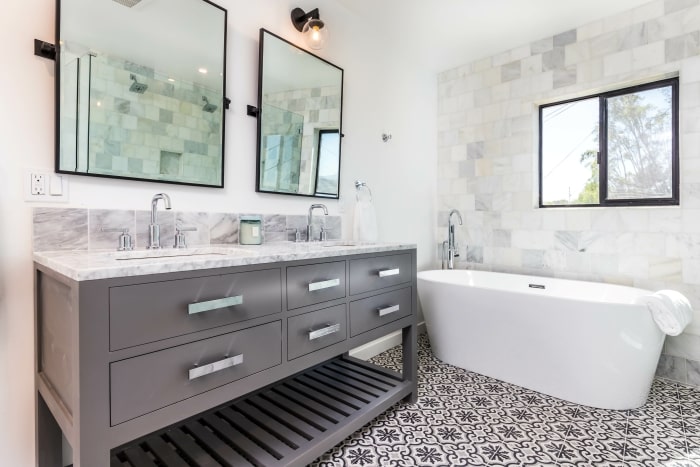 Modern black and white bathroom with freestanding tub.