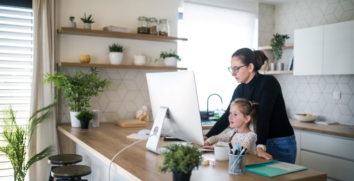 Mom and daughter looking at iMac in kitchen.