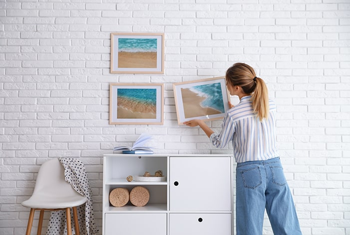 https://www.schlage.com/content/dam/sch-us/blog/post-images/2020/10-october/woman-hanging-picture-frames.jpg