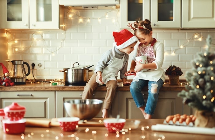 Children in kitchen baking Christmas recipes.