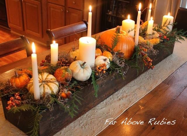 Thanksgiving centerpiece with pumpkins and candles.