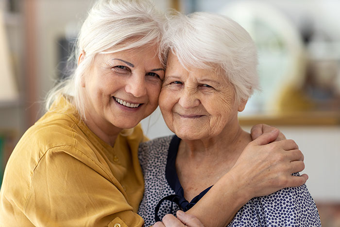 Daughter and elderly mother smiling.